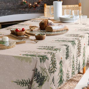 Könnte beinhalten: Eine beige Tischdecke mit einem sich wiederholenden Muster aus grünen und braunen Weihnachtsbäumen. Der Tisch ist mit Brot, Käse und Schalen mit Essen gedeckt. Ein weißer Krug und Teller stehen ebenfalls auf dem Tisch.
