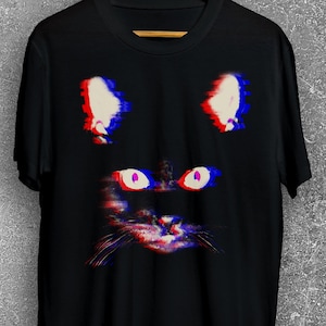Puede incluir: Camiseta negra con una imagen de la cara de un gato con efecto glitch.