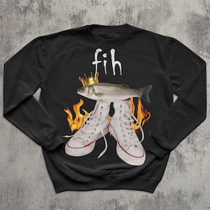 May include: Black sweatshirt with a graphic design featuring a fish wearing a gold crown, white high-top trainers, and flames. The word "fih" is written above the fish in white script.