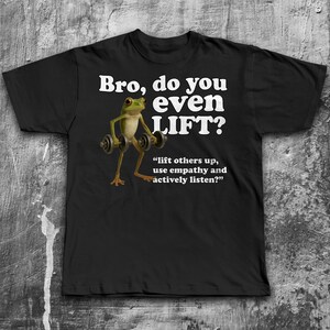 May include: Black t-shirt with the text "Bro, do you even LIFT?" in white. A cartoon frog is lifting weights. Below the text is the quote, "lift others up, use empathy and actively listen?"