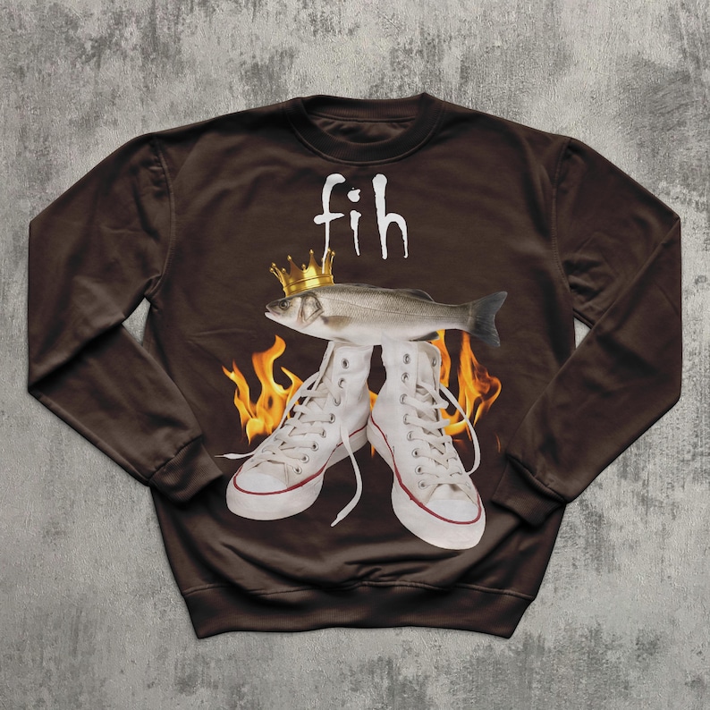 May include: A brown sweatshirt with a fish wearing a gold crown above white high-top trainers. The word "fih" is written above the fish in white. Flames are visible behind the trainers.