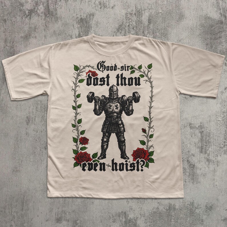 May include: Cream-colored t-shirt featuring a black illustration of a knight lifting dumbbells. The knight is surrounded by a floral border with red roses and the text "Good sir dost thou even hoist?" in gothic lettering.