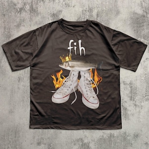 May include: Dark brown t-shirt featuring a graphic design. The design includes the word "fih" above a fish wearing a crown, with white high-top sneakers and flames. The sneakers have red accents.