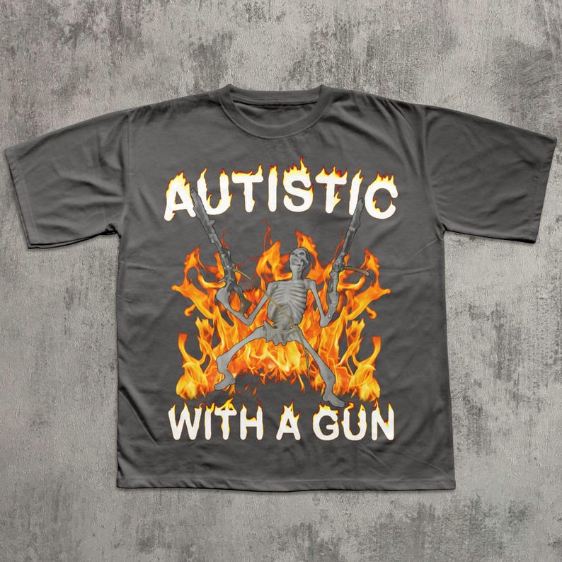 May include: Dark gray t-shirt with the text "AUTISTIC" above a skeleton figure holding two guns, surrounded by flames, and the text "WITH A GUN" below.