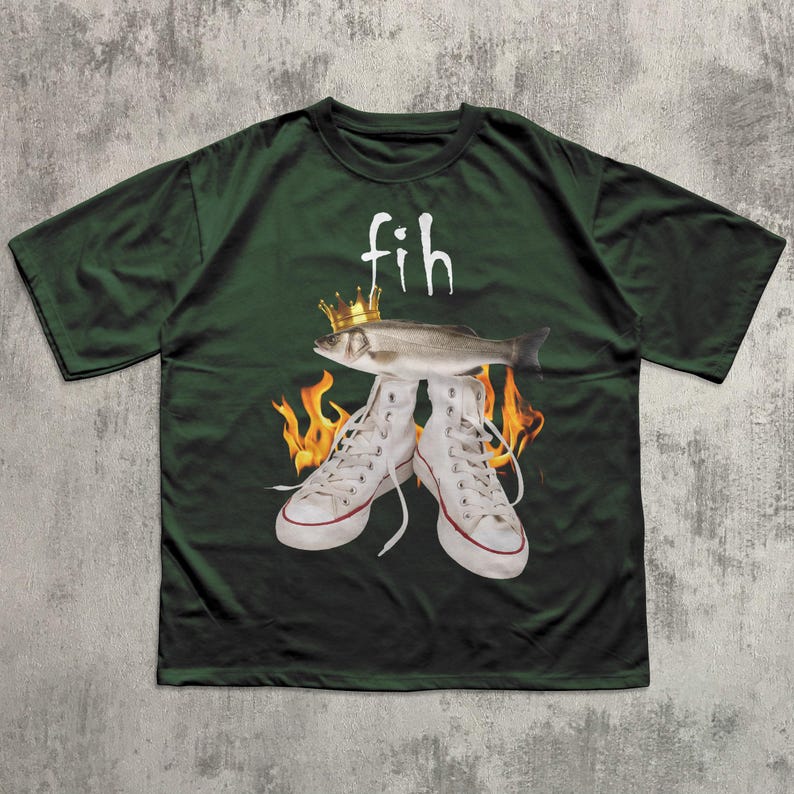 May include: Dark green t-shirt featuring the word "fih" above a fish wearing a crown, with white high-top sneakers and flames. The shirt has a crew neck and short sleeves. The design is centered on the front of the shirt.