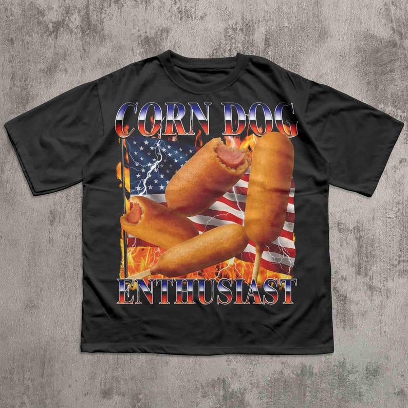Op de afbeelding: Zwart t-shirt met een afbeelding van corn dogs voor een Amerikaanse vlag met vlammen en bliksem. De tekst "CORN DOG ENTHUSIAST" staat in rood, wit en blauw.