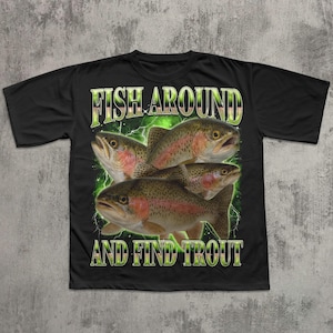 May include: Black t-shirt featuring a graphic of four trout with the text "FISH AROUND AND FIND TROUT" in a green and yellow font. The trout are brown, red, and white, with a green lightning-like background.