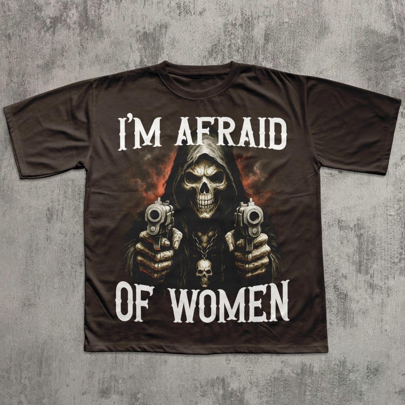 May include: Dark brown t-shirt featuring a grim reaper graphic holding two pistols. The text "I'M AFRAID OF WOMEN" is printed in white above and below the graphic. The shirt has a crew neck and short sleeves.