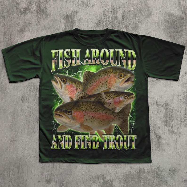 May include: Dark green t-shirt featuring a graphic of four trout fish with the text "FISH AROUND AND FIND TROUT" in a green and yellow font. The fish have red and brown markings. The design includes green lightning bolts.