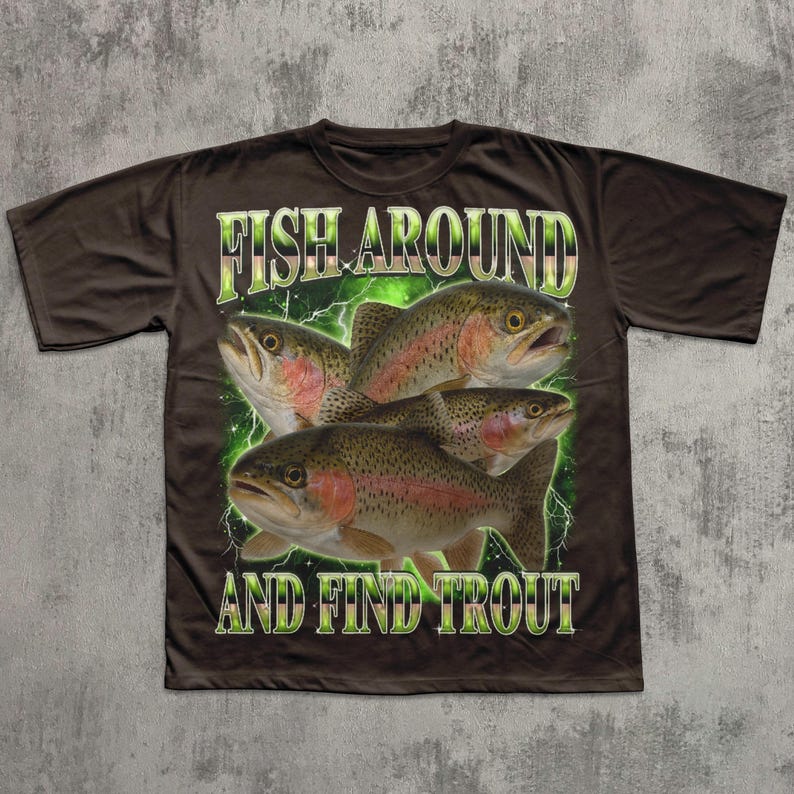 May include: Brown t-shirt featuring a graphic of four trout fish with the text "FISH AROUND AND FIND TROUT" in a green and white design. The fish have red and brown markings.