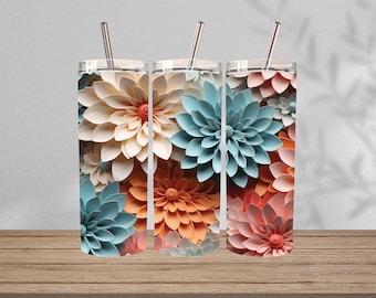 Op de afbeelding: Drie cilindrische bekers met doorzichtige deksels en metalen rietjes, elk voorzien van een levendig, gelaagd papieren bloemenpatroon in tinten crème, teal, oranje en zachtroze, wat een dimensionale uitstraling geeft aan het oppervlak.
