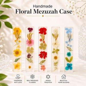 K&ouml;nnte beinhalten: Handgefertigte florale Mezuzah-H&uuml;llen mit echten konservierten Blumen in transparenten rechteckigen H&uuml;llen. Jede H&uuml;lle zeigt eine einzigartige Anordnung farbenfroher Blumen, darunter gelbe, rosa, rote, wei&szlig;e und blaue Bl&uuml;ten. Der Text lautet "Handmade Floral Mezuzah Case."