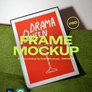 May include: A framed print with a red background and the words "DRAMA QUEEN" in white. A martini glass illustration is visible. The frame is black, and the print is displayed on a green surface. The text "FRAME MOCKUP" is also visible.