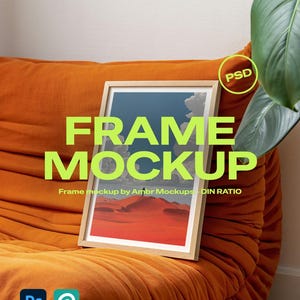 Puede incluir: Una maqueta de obra de arte enmarcada con un marco de madera clara, que muestra un paisaje desértico con tonos rojos y naranjas. El marco descansa sobre un sofá de terciopelo naranja. El texto en la imagen dice "FRAME MOCKUP" y "Frame mockup by Ambr Mockups - DIN RATIO".