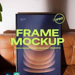 May include: A black framed poster mockup with a dark blue and orange abstract design. The words "FRAME MOCKUP" are in large, bright green letters. The image also includes the text "Frame mockup by Ambr Mockups - DIN RATIO" and the Photoshop and Photopea logos.