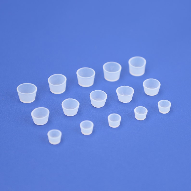 May include: A set of 14 clear silicone caps of varying sizes. The caps are arranged in a semi-circle on a blue background.