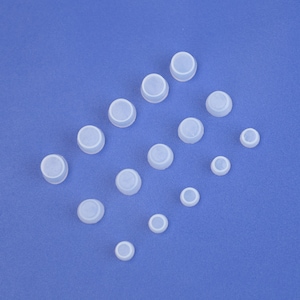 May include: Assortment of white rubber caps of various sizes on a blue background.