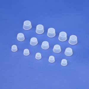 May include: Assortment of clear plastic bottle stoppers in various sizes.