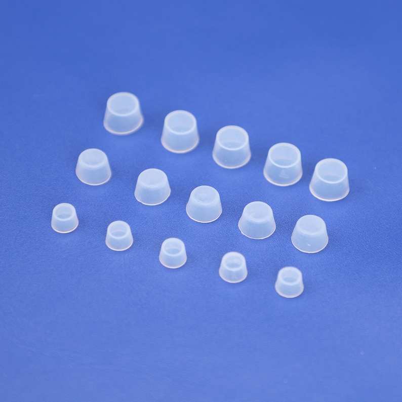 May include: Assortment of clear plastic bottle stoppers in various sizes.