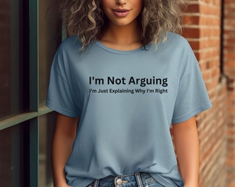 May include: Pale blue crew neck t-shirt featuring the black text "I'm Not Arguing, I'm Just Explaining Why I'm Right". The shirt is made of a soft fabric. The model is wearing blue jeans.