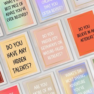 May include: A set of colorful cards with thought-provoking questions for conversation starters. The cards feature a variety of colors and textures, with gold accents.