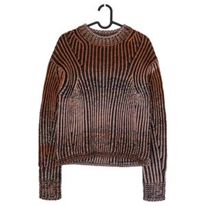 May include: A brown and black striped sweater with a ribbed texture, hanging on a black hanger. The sweater has a crew neck and long sleeves. The color palette includes shades of brown, black, and a hint of pink.