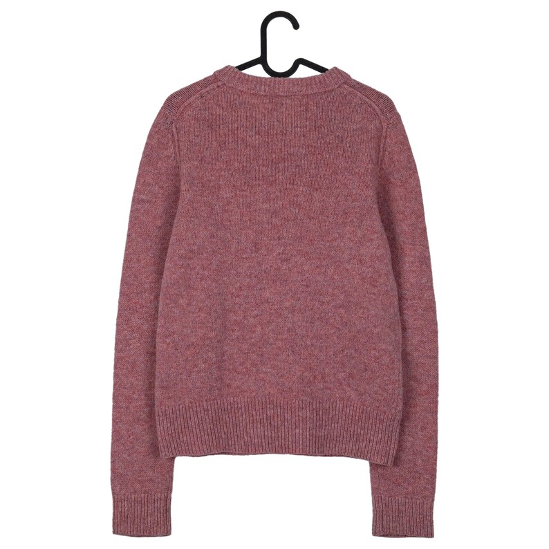 May include: A dusty rose-colored sweater with long sleeves hangs from a black hanger. The knitwear has a crew neck and ribbed cuffs and hem. The sweater's texture appears soft and warm, suitable for cooler weather. The garment is displayed against a plain white background.