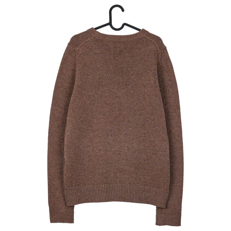 May include: A brown sweater with a crew neck, hanging on a black hanger. The sweater has long sleeves and a ribbed hem and cuffs. The knitwear is a solid color, with a textured appearance.