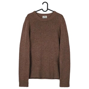 May include: A brown crew neck sweater hanging on a black hanger. The sweater has a ribbed hem and cuffs. The label "Acne Studios" is visible on the neckline. The sweater is made of a soft, textured material.