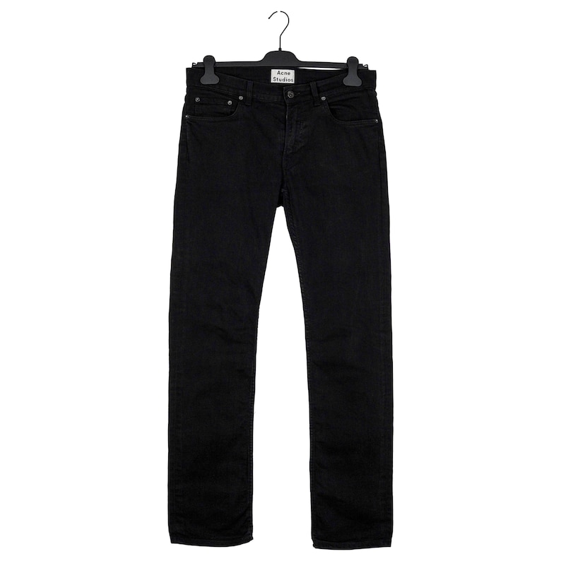 May include: Black denim jeans hanging on a black hanger. The jeans have a classic five-pocket design and a straight leg fit. The brand label "Acne Studios" is visible on the hanger.