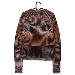 May include: A brown, black, and tan striped sweater hanging on a black hanger. The sweater has a ribbed knit design with a crew neck and long sleeves. The color gradient transitions from light tan to dark brown.