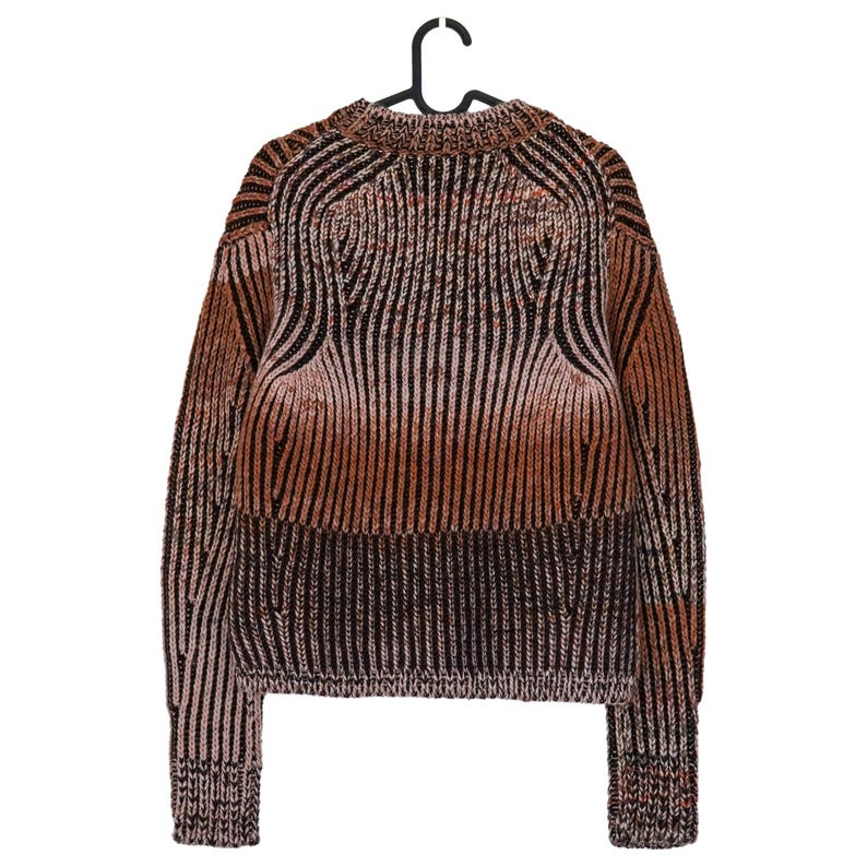 May include: A brown, black, and tan striped sweater hanging on a black hanger. The sweater has a ribbed knit design with a crew neck and long sleeves. The color gradient transitions from light tan to dark brown.