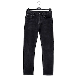 May include: Black denim jeans hanging on a black hanger. The jeans have a classic five-pocket design with a button and zipper closure. The denim has a faded, worn look.