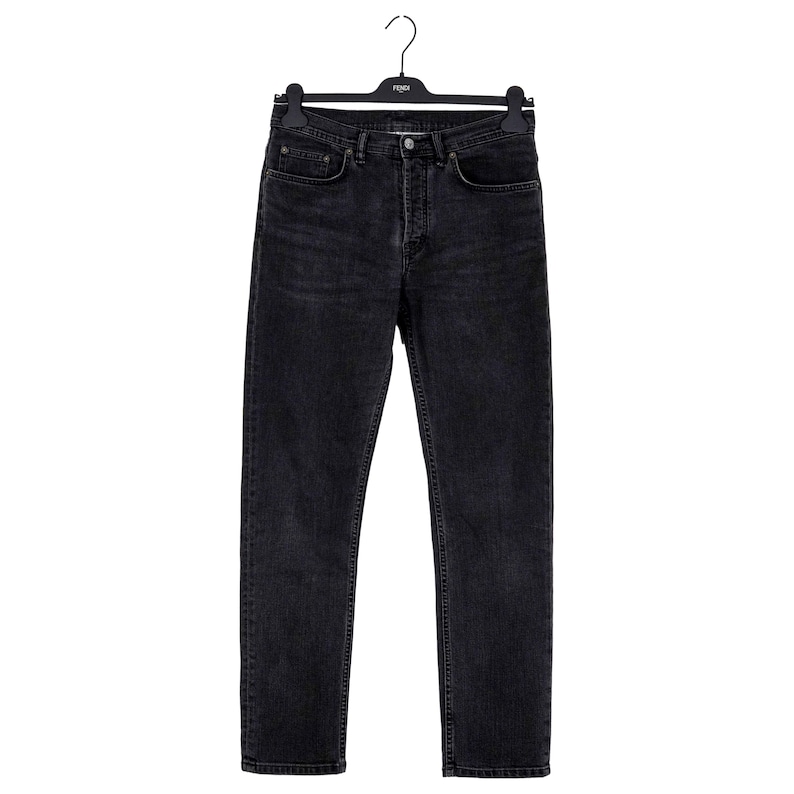 May include: Black denim jeans hanging on a black hanger. The jeans have a classic five-pocket design with a button and zipper closure. The denim has a faded, worn look.