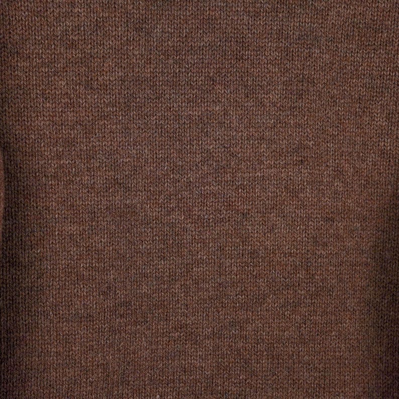 Peut inclure: Gros plan sur un tissu tricot&eacute; marron. La texture est visible, r&eacute;v&eacute;lant les fils individuels et le motif de tissage. La couleur est un marron chaud et terreux, avec de subtiles variations de tons. Le tissu semble doux, peut-&ecirc;tre en laine ou similaire.