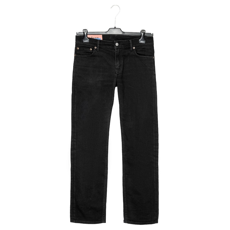 May include: Black denim jeans hanging on a black hanger. The jeans have a classic five-pocket design with a button and zip closure. The jeans are a solid black colour and appear to be made of a durable denim material.