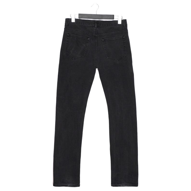 Pu&ograve; includere: Vista posteriore di jeans di denim neri appesi a una gruccia bianca. I jeans hanno un classico design a cinque tasche con gamba dritta. Il denim lavato scuro sembra essere prelavato per una sensazione pi&ugrave; morbida.