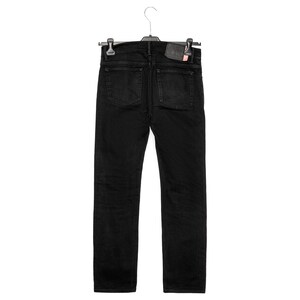 May include: Black denim jeans hanging on a hanger. The jeans have two back pockets and a small leather patch. The jeans are a solid black colour and appear to be new.