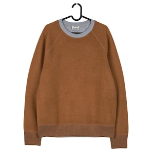 May include: A brown crew neck sweater with a grey neckline and ribbed cuffs and hem. The sweater is hanging on a black hanger. The brand name "Acne Studios" is visible on the neckline.