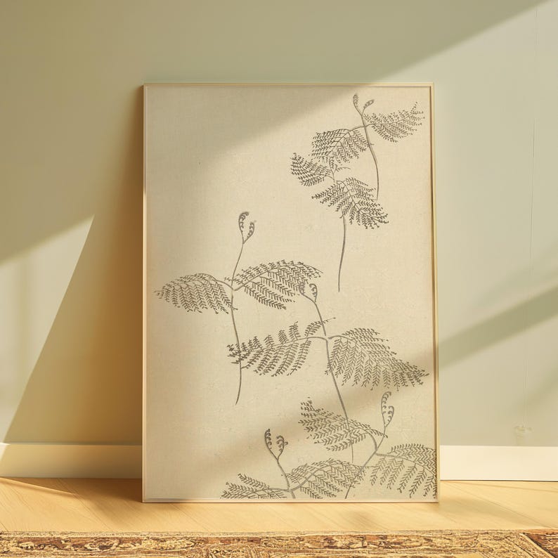 May include: A framed botanical print featuring a detailed illustration of fern-like plants in shades of gray and beige. The artwork is displayed against a neutral background, creating a minimalist aesthetic. The print is encased in a light-colored wooden frame.