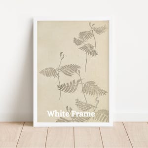 May include: White framed botanical print featuring detailed illustrations of fern-like plants in shades of brown against a cream-colored background. The text "White Frame" is printed at the bottom. The artwork is encased in a white frame.