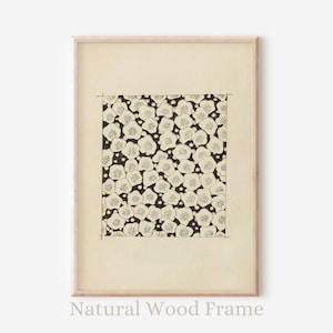 Pode incluir: Uma impressão emoldurada de um padrão floral preto e branco com flores brancas e centros azuis. A impressão é emoldurada em uma moldura de madeira natural.