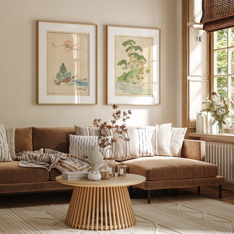 May include: A brown sectional sofa with striped throw pillows and a brown throw blanket. The sofa is in a living room with a wooden coffee table and two framed prints of Japanese landscapes on the wall.
