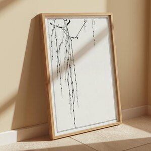 Pode incluir: Um desenho a preto e branco de um ramo de salgueiro chor&atilde;o com folhas delicadas. A obra de arte est&aacute; sobre um fundo branco e emoldurada numa moldura de madeira natural.