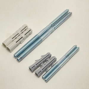 May include: Two sets of screws and wall anchors. One set is silver with a white plastic anchor and the other set is silver with a gray plastic anchor.