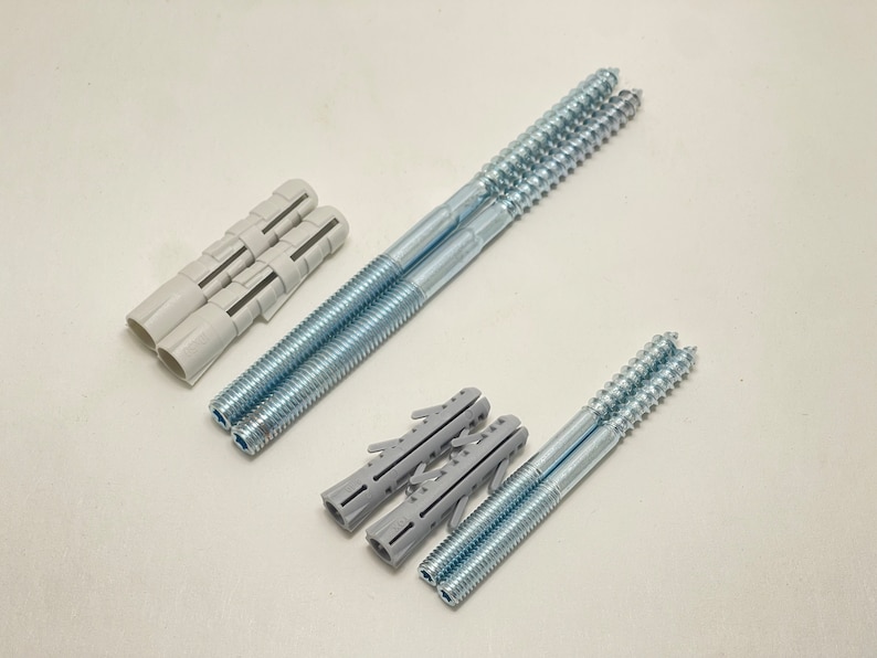 May include: Two sets of screws and wall anchors. One set is silver with a white plastic anchor and the other set is silver with a gray plastic anchor.