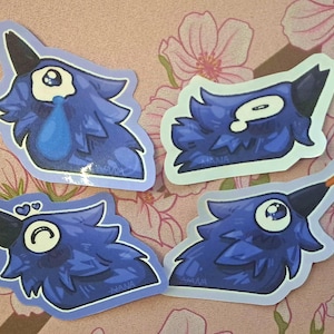 May include: Four die-cut stickers featuring stylized blue bird heads with dark beaks. One bird cries a blue tear, one has a flat expression, one has heart eyes, and one has an orange tongue sticking out. Each sticker includes the name HANA.