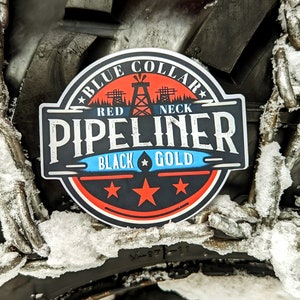 Puede incluir: Un neumático negro con una cadena envuelta alrededor. El neumático tiene una pegatina que dice "Blue Collar Red Neck  Pipeliner Black Gold" con una estrella y un gráfico de una torre de perforación.