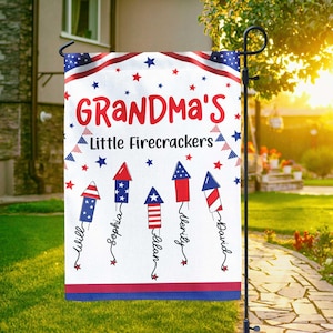 May include: A white garden flag with a red, white, and blue patriotic design. The flag reads "Grandma's Little Firecrackers" with names below stylized firework illustrations. The flag has a red and blue border with stars.