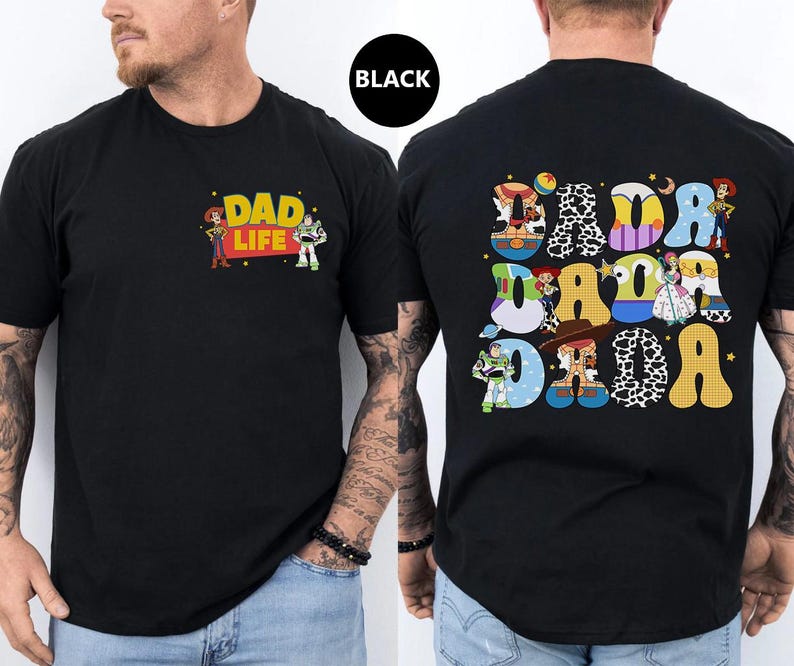 May include: Black t-shirt with a Toy Story theme. The front of the shirt says "Dad Life" with Woody and Buzz Lightyear characters. The back of the shirt has a large "Dada" spelled out with different Toy Story characters in each letter.